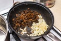 Mushrooms fried whole in a pan with onions on a gas stove. Royalty Free Stock Photo