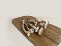 Mushrooms are lying on a wooden board. Autumn forest still life in beige colors Royalty Free Stock Photo