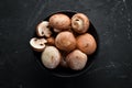 Mushrooms in a plate. Champignons on the old background. Top view. Royalty Free Stock Photo