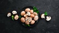 Mushrooms in a plate. Champignons on the old background. Top view. Royalty Free Stock Photo