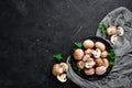 Mushrooms in a plate. Champignons on the old background. Top view. Royalty Free Stock Photo