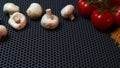 Mushrooms tomatoes on a branch and pasta on a dark background on top