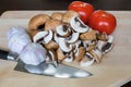 Mushrooms Tomatoes Garlic Cloves Kitchen Knife on Cutting Board Royalty Free Stock Photo