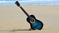 An old blues guitar forgotten on the beach in late summer Royalty Free Stock Photo