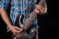 Music and art. Electric guitar in the hands of a guitarist, on a black isolated background. Playing guitar. Horizontal frame Royalty Free Stock Photo