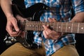 Music and art. Electric guitar in the hands of a guitarist, on a black isolated background. Playing guitar. Horizontal frame Royalty Free Stock Photo