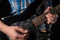 Music and art. Electric guitar in the hands of a guitarist, on a black isolated background. Playing guitar. Horizontal frame Royalty Free Stock Photo