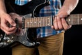 Music and art. Electric guitar in the hands of a guitarist, on a black isolated background. Playing guitar. Horizontal frame Royalty Free Stock Photo