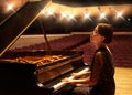 Music is an artform. a young woman playing the piano during a musical concert.