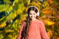 Music for autumn mood. Kid girl relaxing near autumn tree with headphones. Listening song. Enjoy music fall day. Autumn