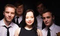 music band in studio.Musicians and woman soloist posing over black background Royalty Free Stock Photo