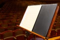 Music book and sheets with musical notation on the stand ready to the concert. Equipment of the Orchestra in philharmonia