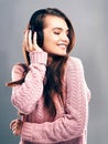 Music brings back great memories. Studio shot of a beautiful young woman listening to music against a gray background.