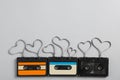 Music cassettes and hearts made of tape on light grey background, flat lay with space for text. Listening love songs