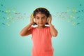 Music, childhood and technology concept- little indian girl with headphones over green color backgroundound with musical notes Royalty Free Stock Photo