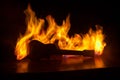 Music concept. Acoustic guitar on a dark background under beam of light with smoke with copy space. Exploding guitar. Fire effects