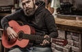 Music concept. Bearded guitarist plays. Guitars and strings. Bearded man playing guitar, holding an acoustic guitar in Royalty Free Stock Photo