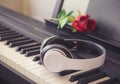 Music and  concept.Music headphone on piano keyboard with red rose.vintage filtered,selective focus Royalty Free Stock Photo