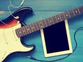 Vintage guitar with earphones on wood Royalty Free Stock Photo