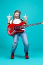 Music Concepts. Expressive Caucasian Guitar Player Posing and Playing Electro Guitar With Showing V Gesture on Trendy Green -Blue