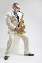 Music Concepts. Hadnsome Male Saxophone Player Playing in Studio