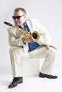 Music Concepts and Ideas. Portrait of Hadnsome Male Saxophone Player in Sunglasses Posing in White Suit