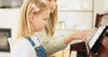 Music development, girl learning piano and musical note education from mom in the home living room. A child musician Royalty Free Stock Photo
