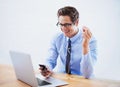 Music energizes his work. A handsome young businessman choosing a song from his smartphones playlist.