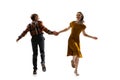 Dynamic portrait of stylish dancers, young man and woman in vintage attire dancing swing isolated on white background