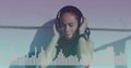 Music equalizer against close up of african american woman wearing headphones listening to music