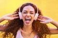 Music, face and shouting with a black woman listening to the radio outdoor on a yellow wall background. Headphones Royalty Free Stock Photo