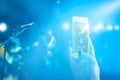 Music fans takes a photo guitarist on stage in concert on smartphone, Pastel color tone and soft focus