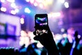 Music fans takes picture of stage in concert on smartphone. Royalty Free Stock Photo