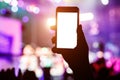 Music fans takes picture of stage in concert on smartphone. Royalty Free Stock Photo