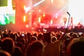 Music festival atmosphere with vibrant stage lights, enthusiastic audience enjoying live performance, fans capturing Royalty Free Stock Photo