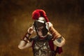 Portrait of medieval person, young man, warrior or knight in war equipment isolated on vintage dark background Royalty Free Stock Photo