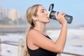 Music, fitness and woman drinking water at the beach for sports, running and cardio routine. Podcast, bottle and thirsty Royalty Free Stock Photo