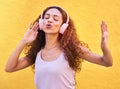 Music, freedom and singing with a black woman listening to the radio outdoor on a yellow wall background. Headphones Royalty Free Stock Photo