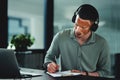 Music gives me motivation to get through the day. a young businessman writing on a notepad in an office at work. Royalty Free Stock Photo