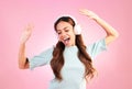 Music headphones, dancing and woman singing in studio isolated on a pink background. Singer, radio dance and happy mixed