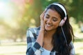 Music, headphones or happy woman in park to relax in garden, nature or field with smile or peace. Eyes closed, streaming Royalty Free Stock Photo