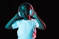 Portrait of little African-American girl isolated on dark background in neon Royalty Free Stock Photo