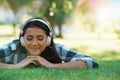 Music headphones, park or woman on grass to relax for rest in garden, nature or field with smile or peace. Eyes closed Royalty Free Stock Photo