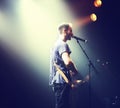 Music from the heart. Shot of a solitary musician playing guitar and singing into a mic.