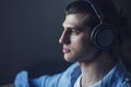 Music in his mind. Portrait of young man wearing headphones and looking away Royalty Free Stock Photo