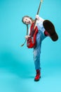 Music Ideas and Concepts. Expressive Caucasian Guitar Player Posing and Playing Electro Guitar With Lifted Leg in Boots on Trendy