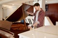 Man buyer looking on tuning keys inside grand piano under lid Royalty Free Stock Photo