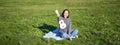 Music and instruments. Portrait of cute asian girl shows her white ukulele, plays in park while sitting relaxed on Royalty Free Stock Photo