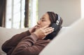 When the music just gets you in that calm mood. a young woman listening to music while relaxing on a sofa at home.