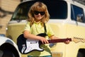 Music kids. Funny little hipster musician child playing guitar.